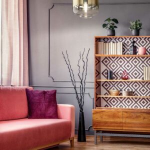 antique-wooden-bookcase-with-decorations-in-an-elegant-gray-living-room-interior-with-a-comfortable-powder-pink-sofa