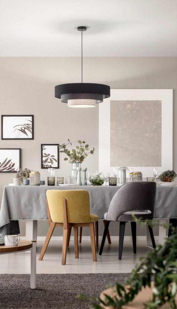 grey-and-yellow-chair-at-table-under-lamp-in-dining-room-interior-with-posters-and-plants-real-photo